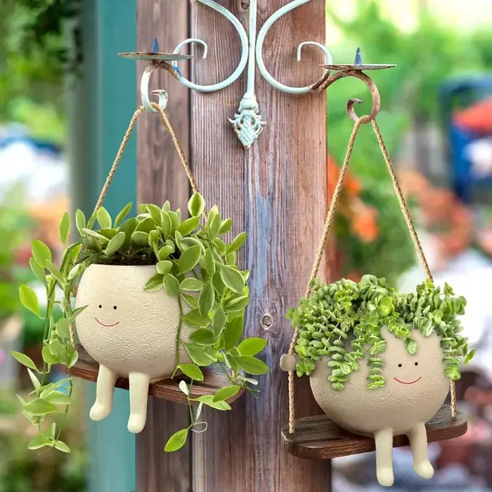Pot de fleurs créatif en forme de tête de personne assise sur une balançoire