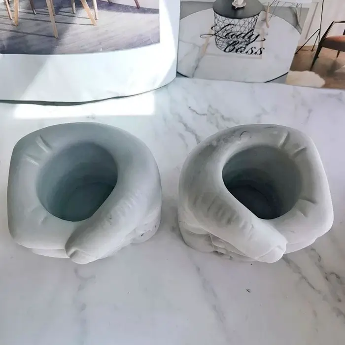 Pot de fleurs en béton en forme de l'hypothèse à la main