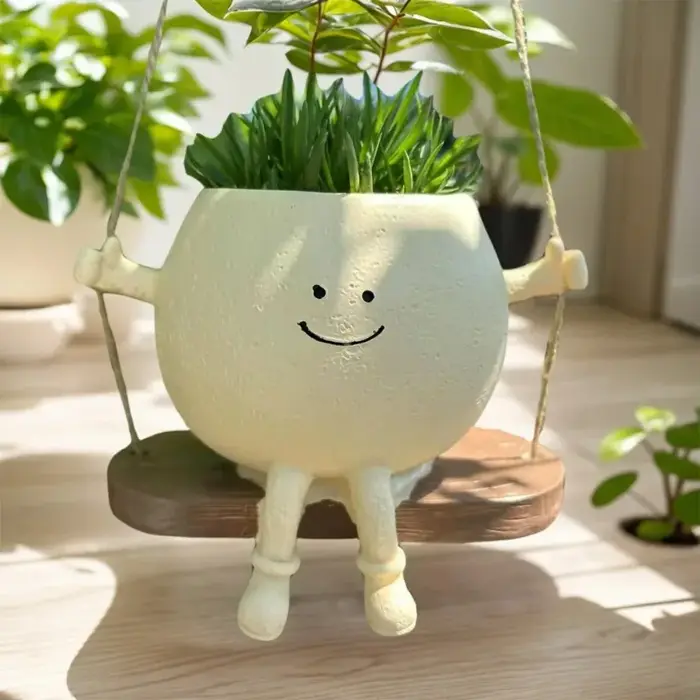Pot de fleurs créatif en forme de tête de personne assise sur une balançoire
