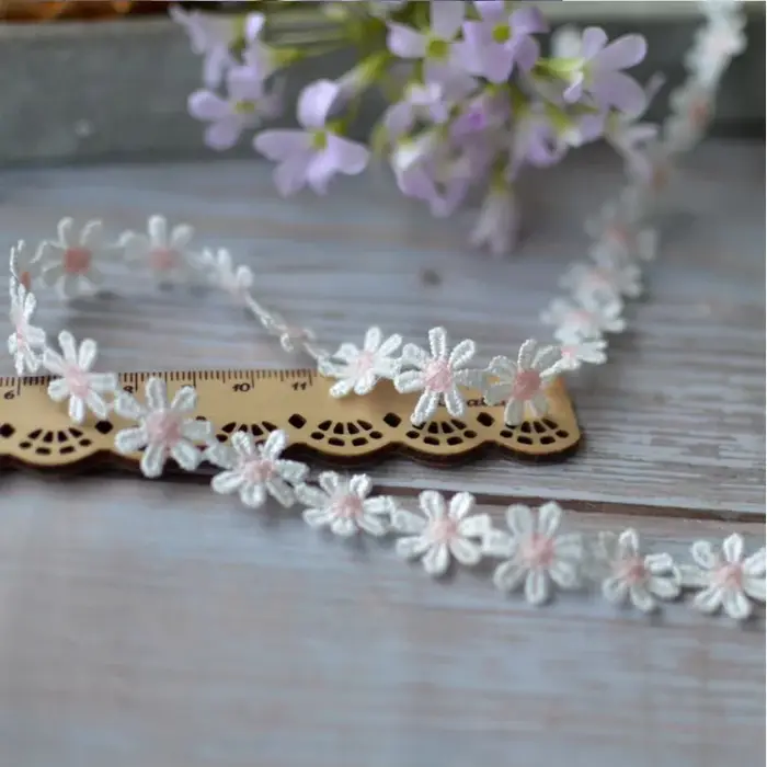 Tissu en dentelle brodée de fleurs de marguerite dorées