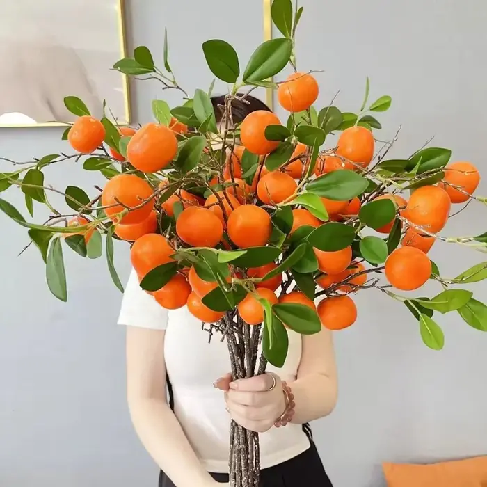 Branche d'orange artificielle avec feuilles vertes réalistes