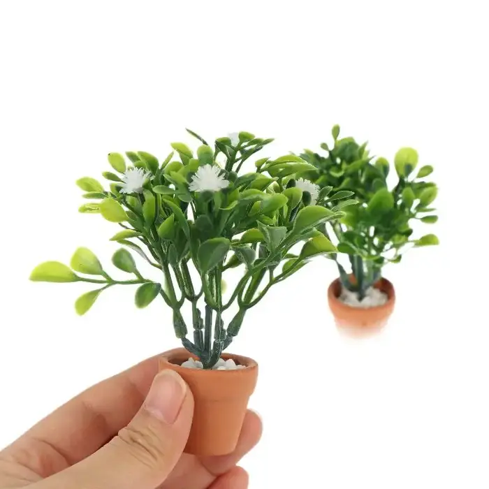 Miniature de fleur blanche et de plante verte en pot